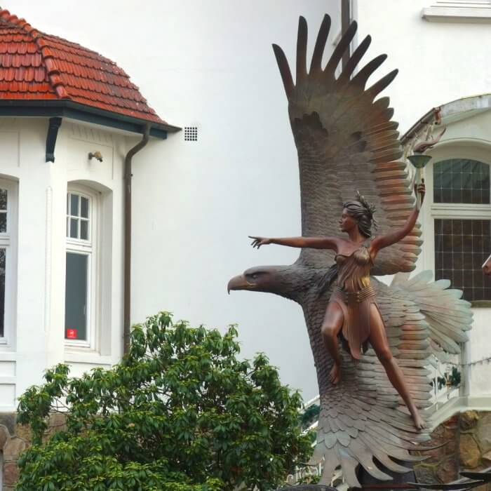 Eine Amazone aus Bronze steht auf den dem Flügel eines Adlers, Statue von Osprey Orielle Lake